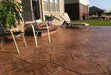 A backyard patio has been stamped and colored to mimic flagstone